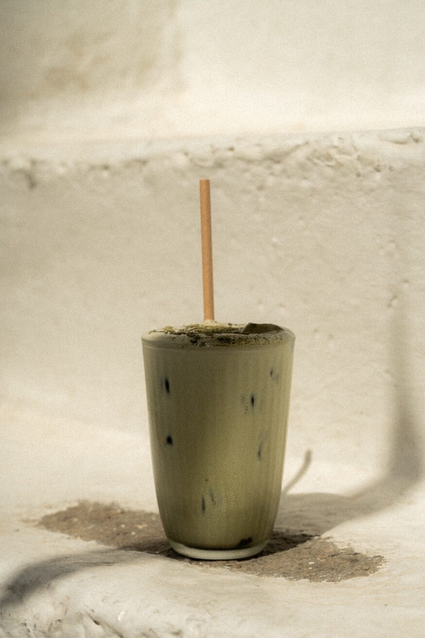Ceremonial grade iced matcha on whitewashed Mykonos wall — the only matcha bar in Mykonos